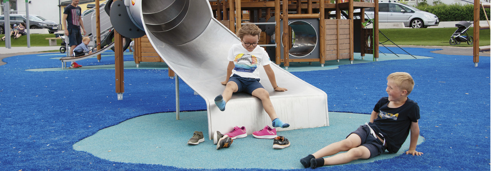 Children kicking their shoes off at the bottom of a slide